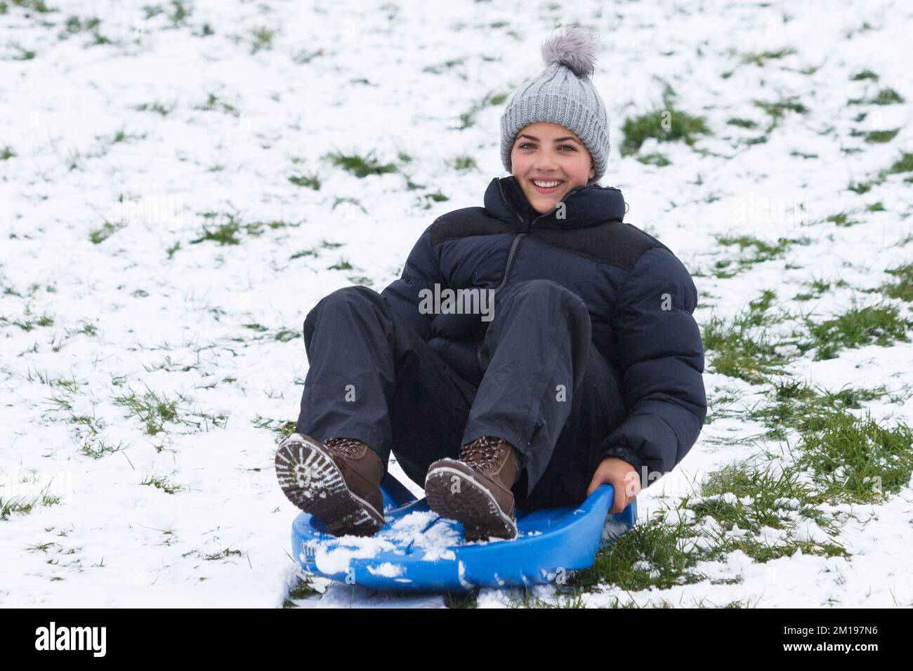 Chippenham, Wiltshire, UK, 11th Dec, 2022. As Chippenham residents wake up to their first snow of the year, a woman is pictured in a local park in Chippenham as she speeds down a hill on a sledge. Credit: Lynchpics/Alamy Live News. Stock Photo