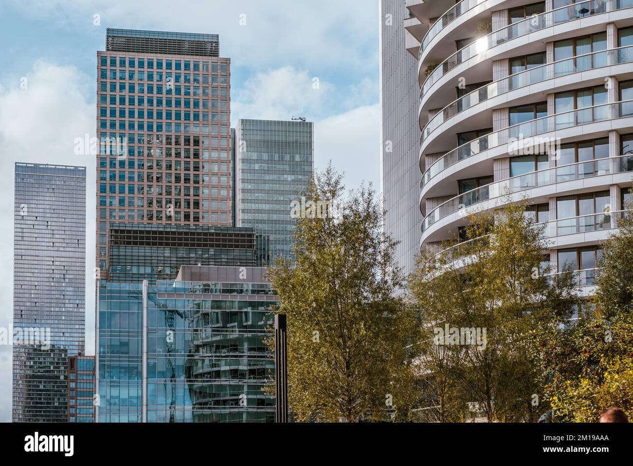 Detail of high-rise buildings at Harbour Quay Gardens, Wood Wharf, with reflections in windows and trees with fall foliage, Canary Wharf, London Stock Photo