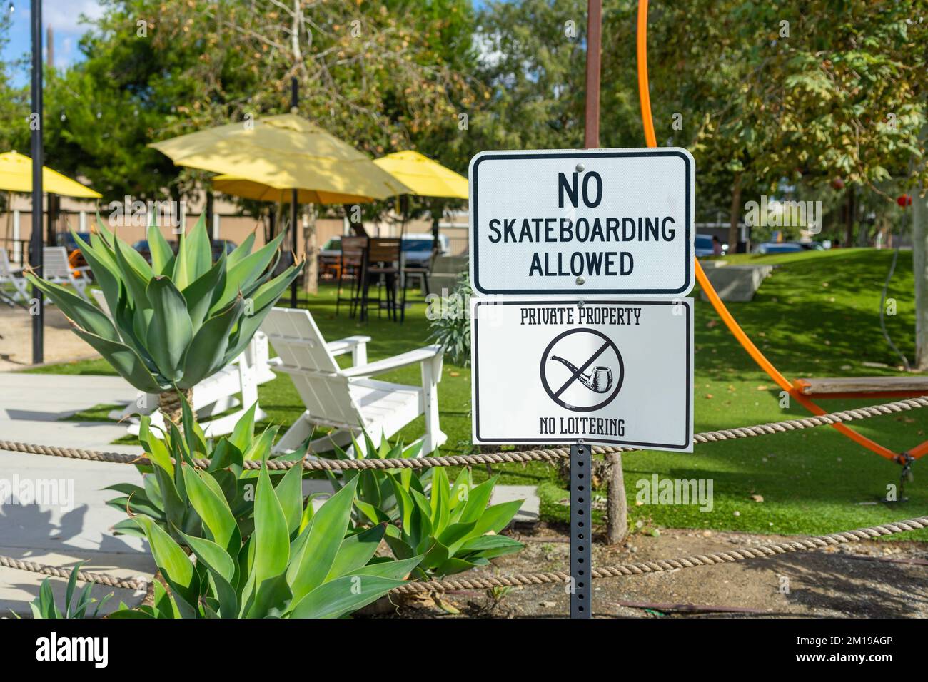 Anaheim, CA, USA – November 2, 2022: No Skateboarding Allowed and Private Property, No Loitering signs on a park adjacent to the Anaheim Packing House Stock Photo