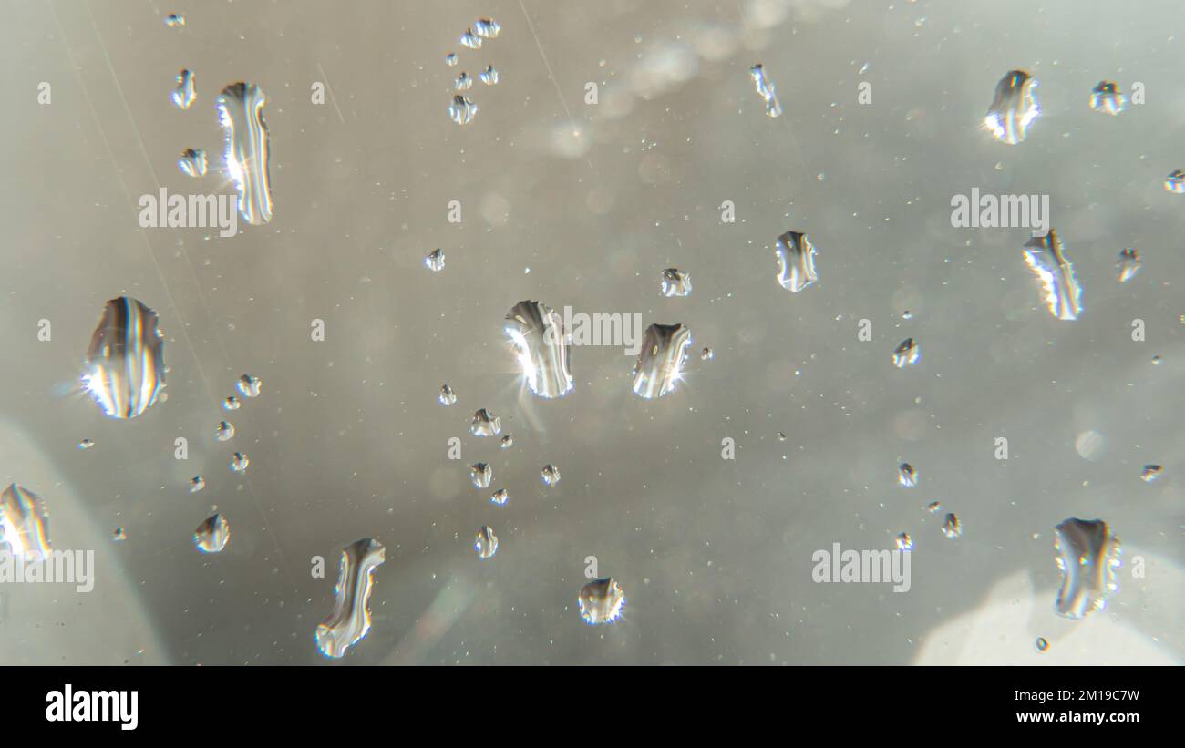 Raindrops fall on the window close-up. Rain, rainy, depressive, dreary weather. Wet drop water. Splashes of water with large drops on the glass. On wi Stock Photo