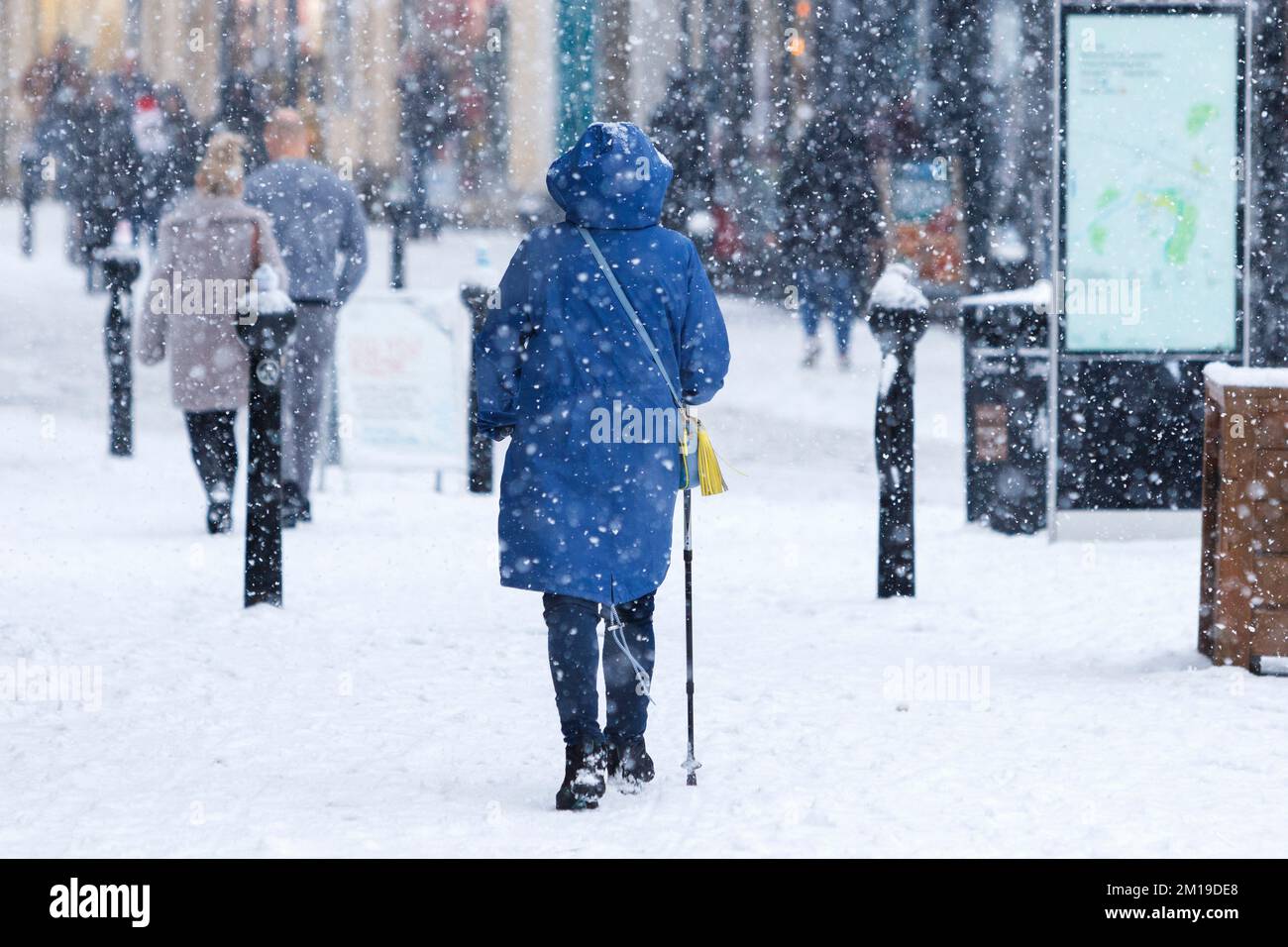 Chippenham, Wiltshire, UK, 11th Dec, 2022. As Chippenham residents wake up to their first snow of the year, shoppers are pictured walking in the High Street as heavy snow falls.  Credit: Lynchpics/Alamy Live News. Stock Photo