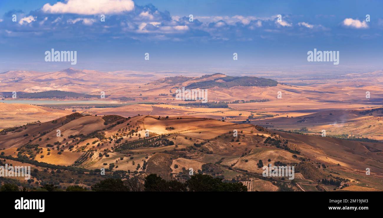 Wide angle view of the vast panorama of cultivated fields, productive settlements, hills and sea, taken from the archaeological site of Morgantina in Stock Photo