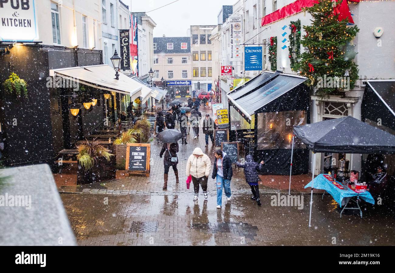 Brighton UK 11th December 2022 - Christmas shoppers walk through snow in the centre of Brighton as the cold weather is forecast to last for the next few days throughout Britain . : Credit Simon Dack / Alamy Live News Stock Photo