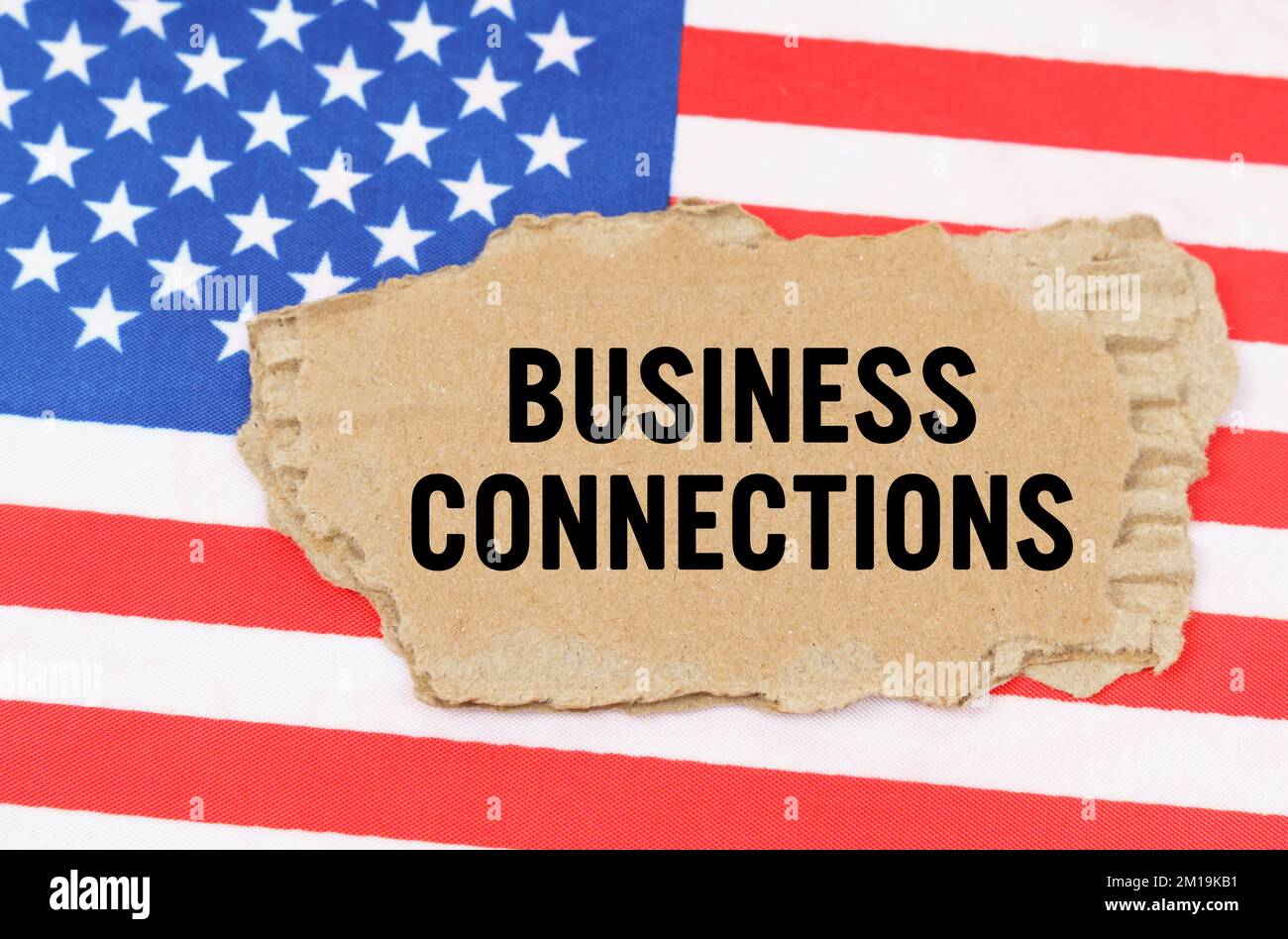 Business and finance concept. On the US flag lies a cardboard box with ...