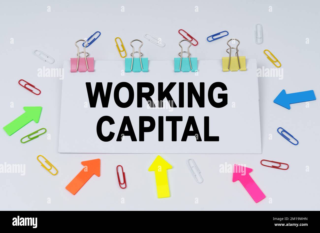 Business and finance concept. On the table there are paper clips and directional arrows, a sign that says - Working Capital Stock Photo