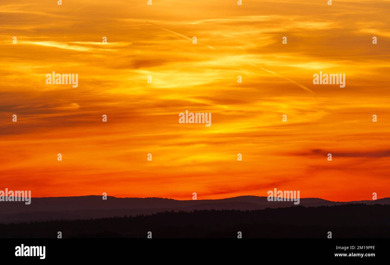 A splendid fiery sunset over the hills and trees Stock Photo - Alamy