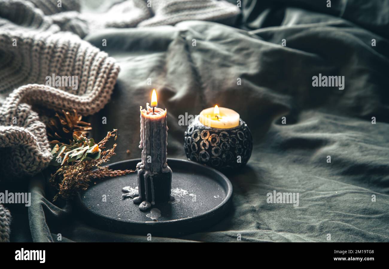 Cozy home composition with candles in bed. Stock Photo