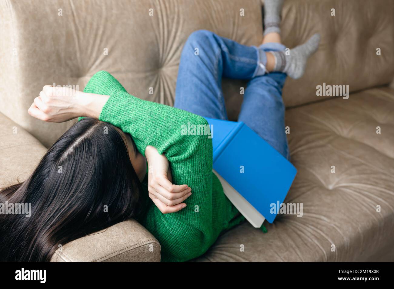 Tired woman sleeping on sofa with notepad, overwork concept Stock Photo
