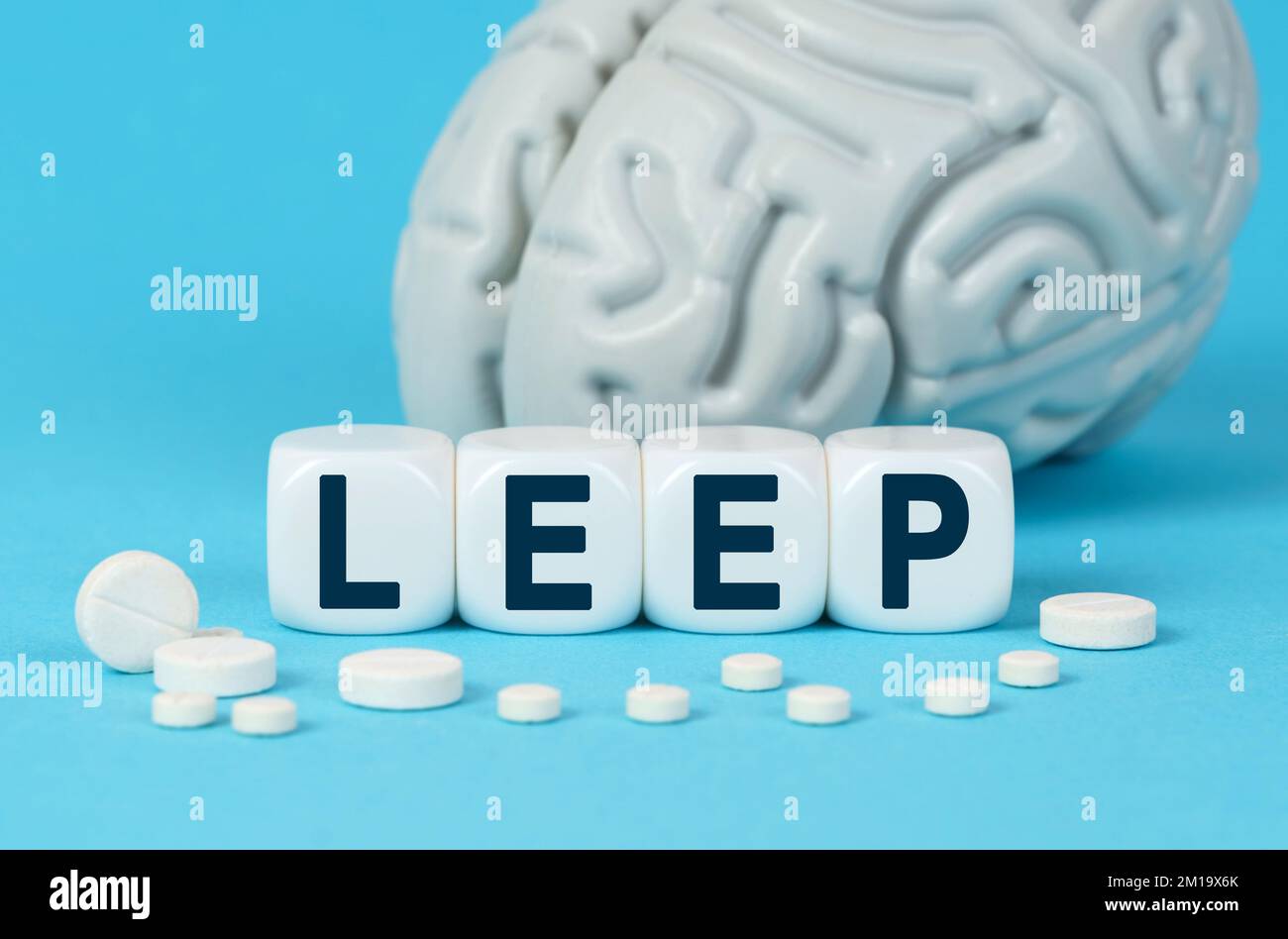 Medicine and health. Cubes lie on the table among the pills and imitation of the brain. The text on the dice - LEEP Stock Photo