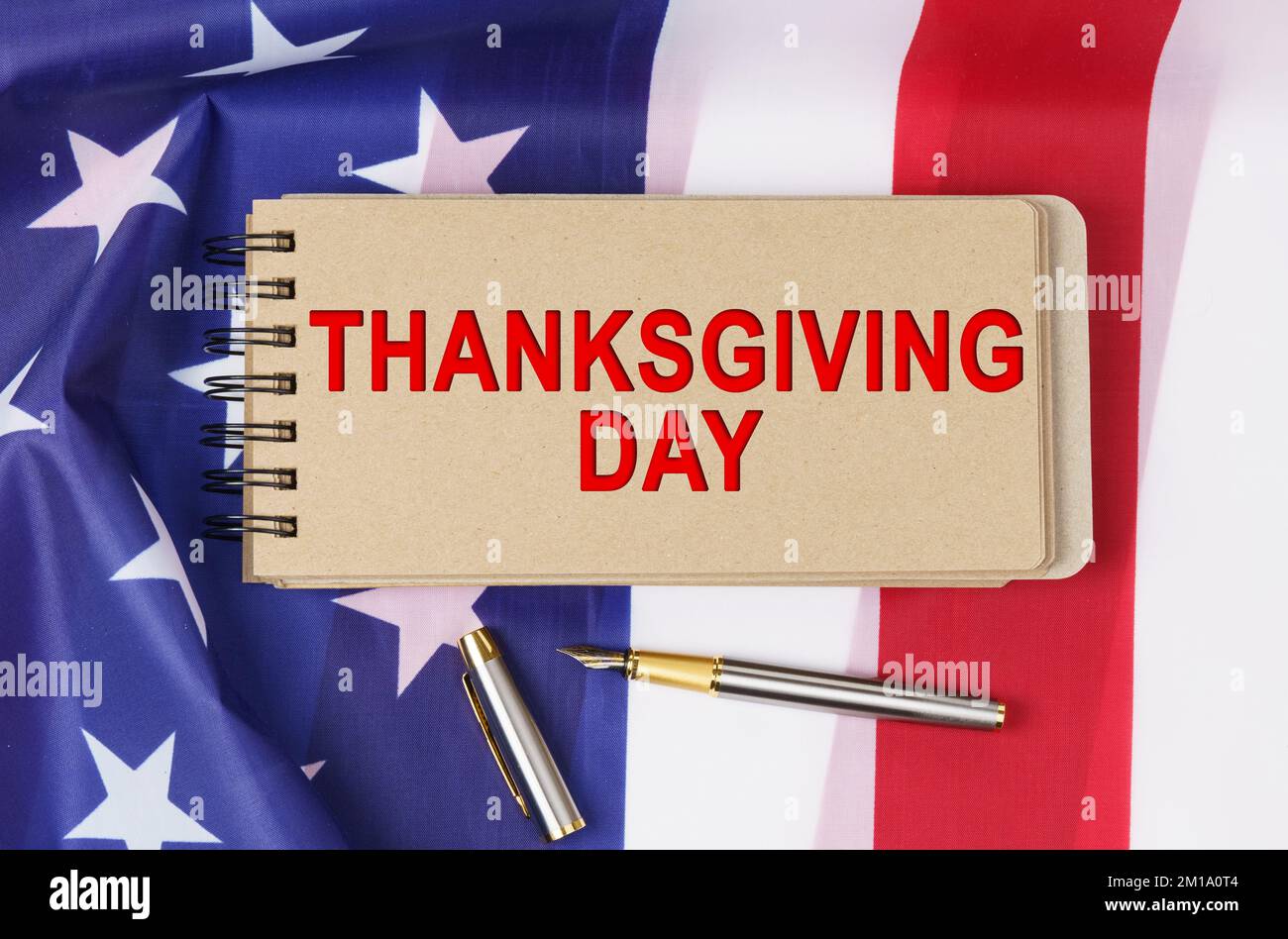USA Holidays. Against the background of the US flag lies cardboard with the inscription - THANKSGIVING DAY Stock Photo