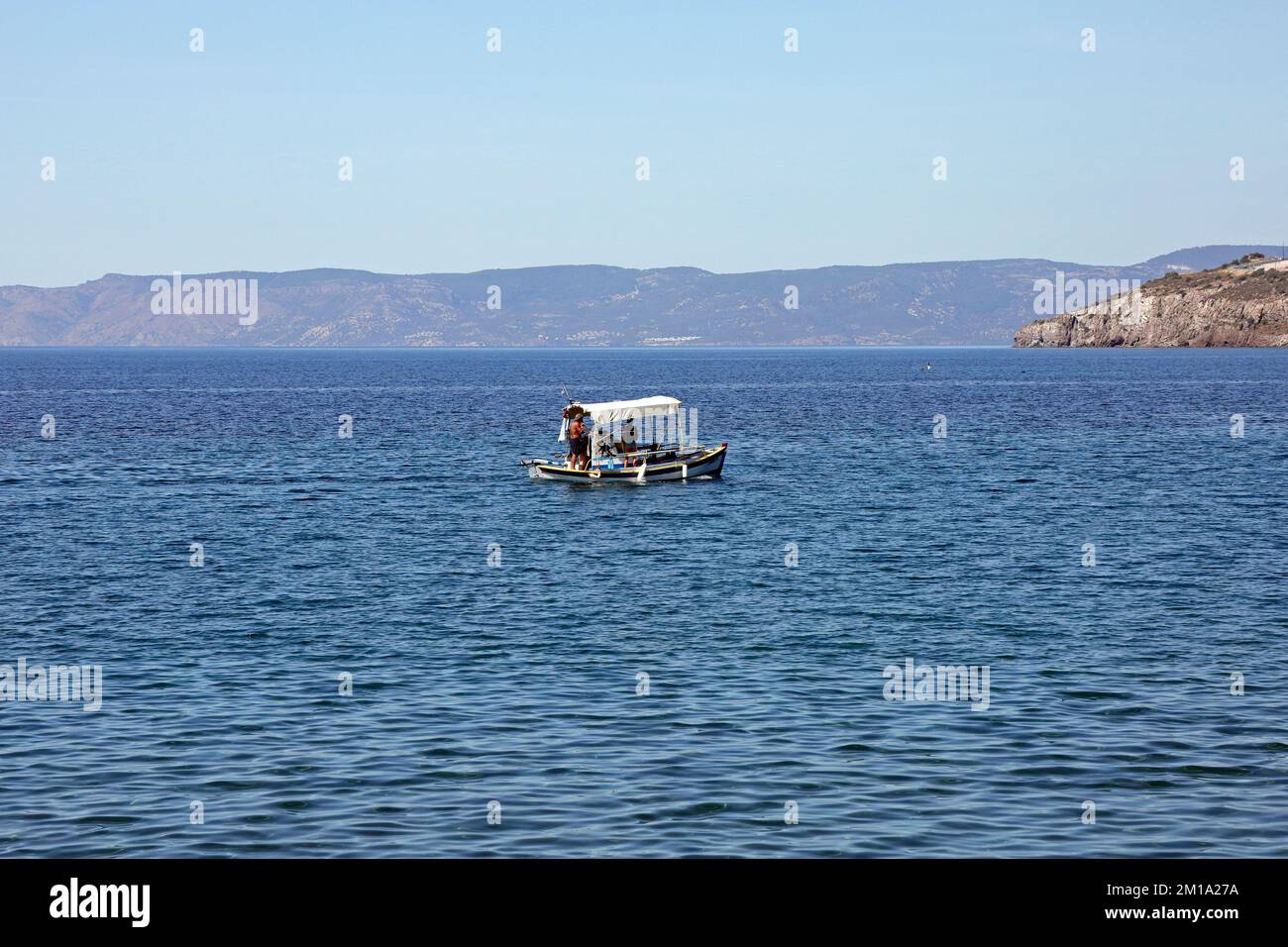 Lesbos scenes. Small fishing boat with family aboard, low in the water September / October 2022. Stock Photo