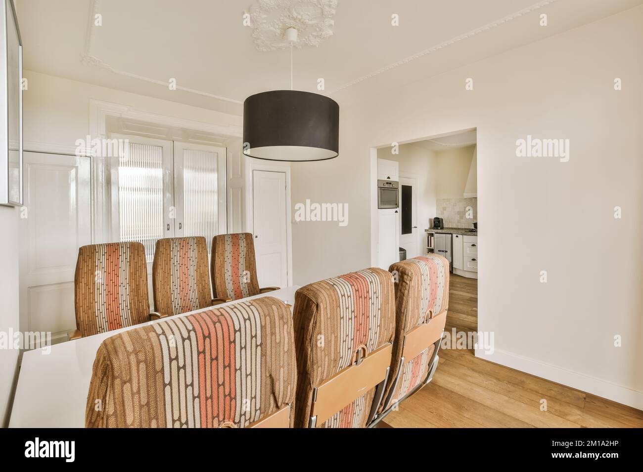 a living room with chairs and a lamp hanging above the dining table in
