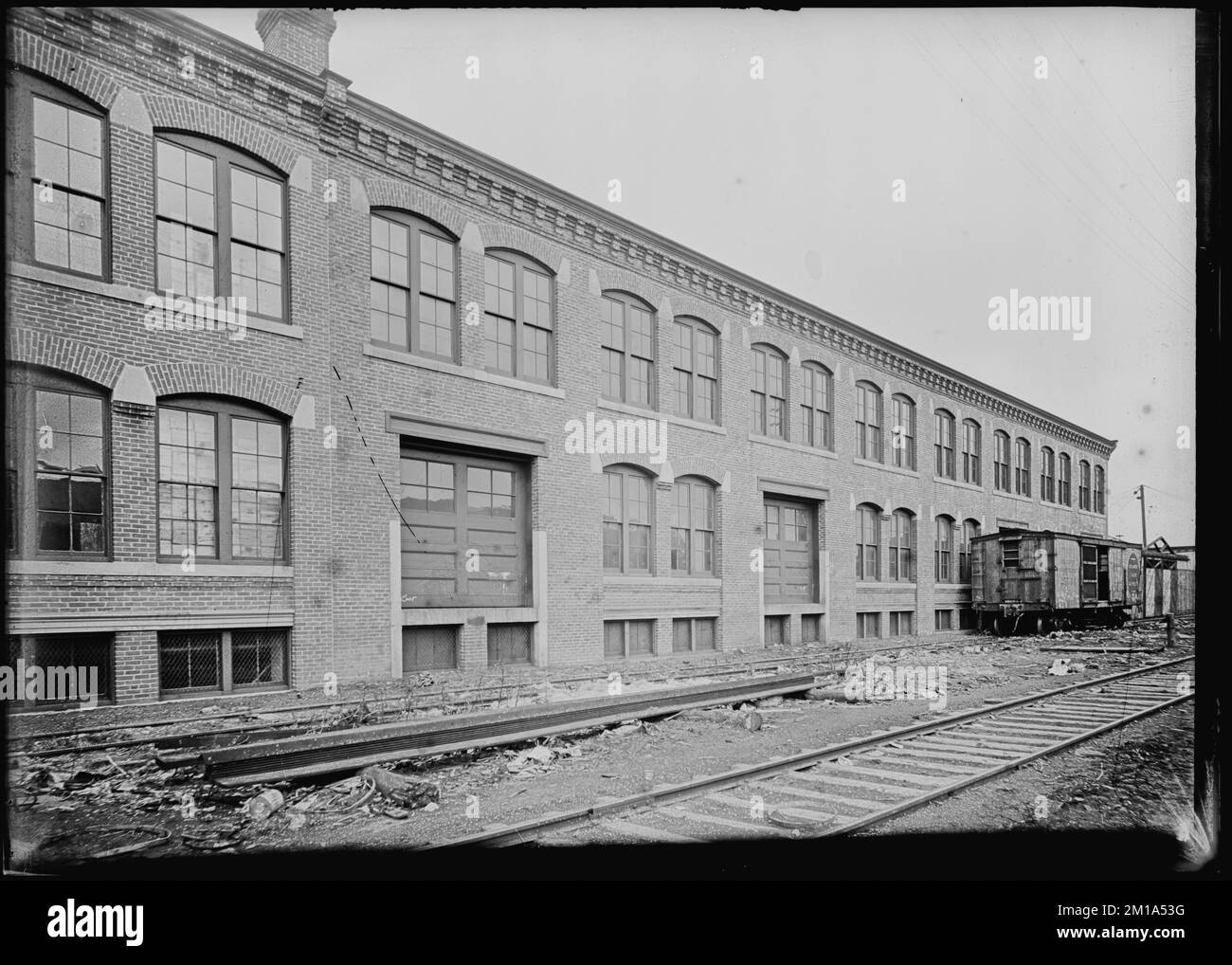 Two story warehouse along railroad spur, showing railroad car 19001907