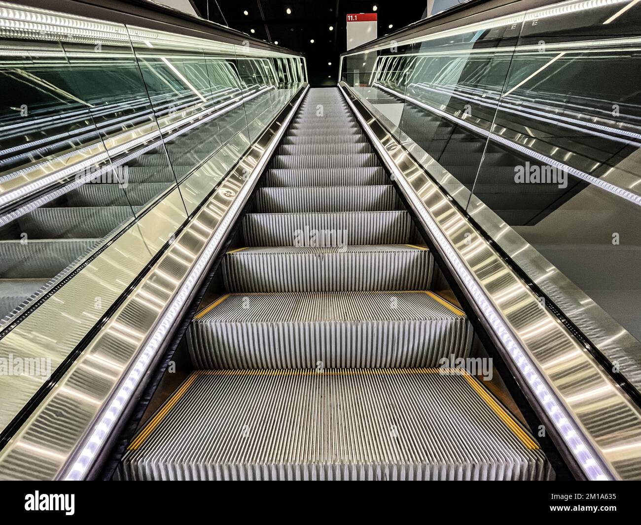 Moving up in a escalator with glass sides in a modern building Stock Photo
