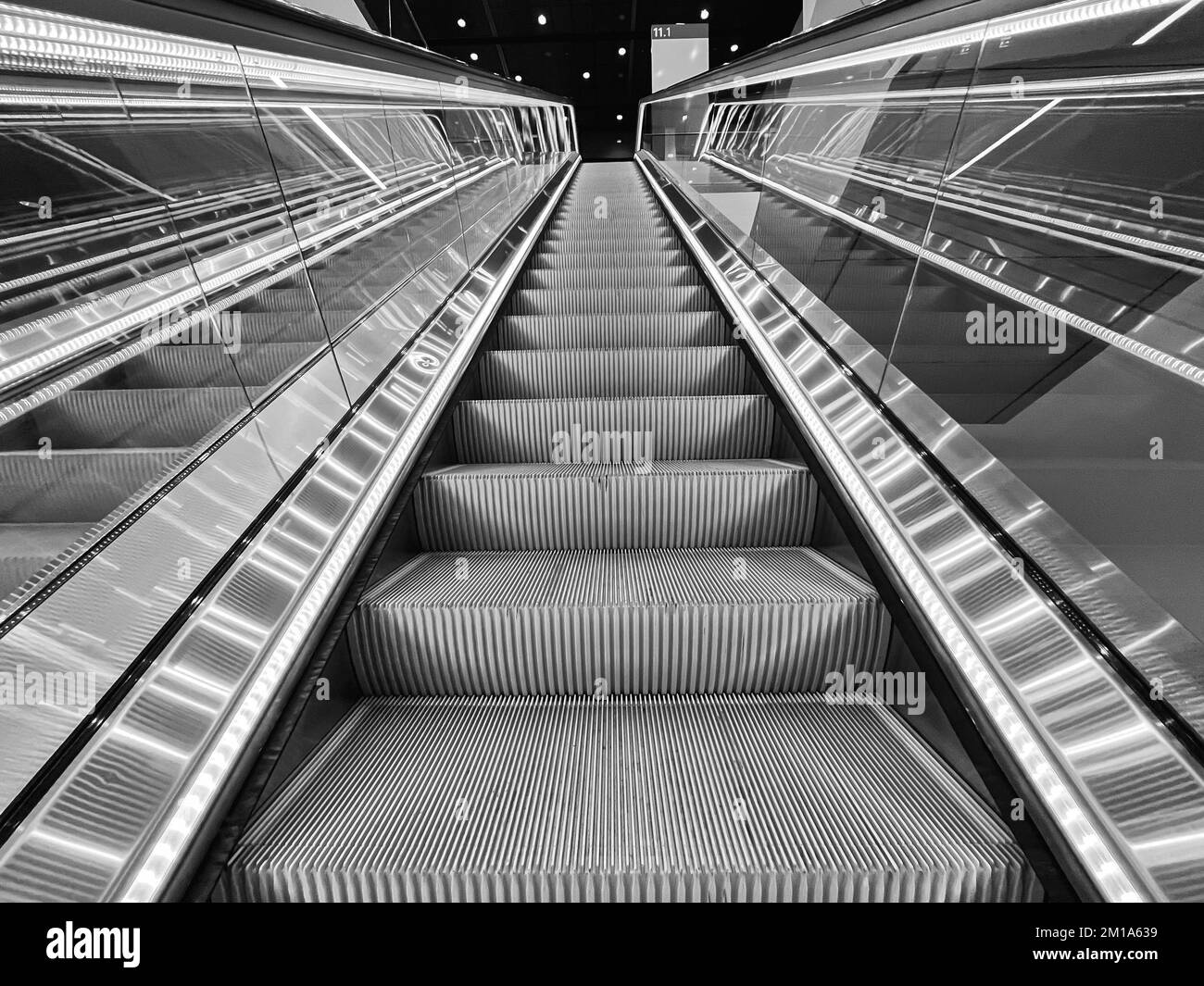 Moving up in a escalator with glass sides in a modern building Stock Photo