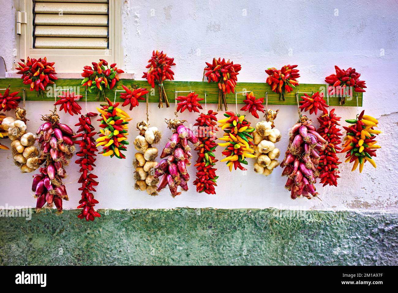 Vieste Gargano. Apulia Puglia Italy. Red chili,shallot and garlic hanged to dry outside a house Stock Photo