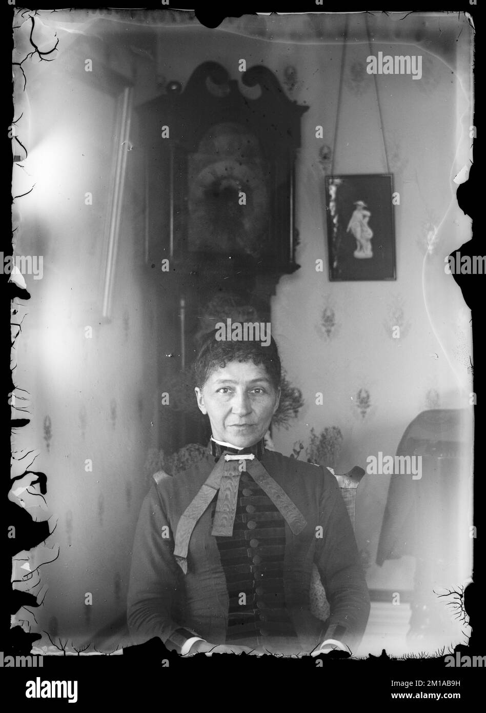 Unidentified woman sitting in front of same grandfather clock , People. Hingham Public Library Glass Slide Collection Stock Photo