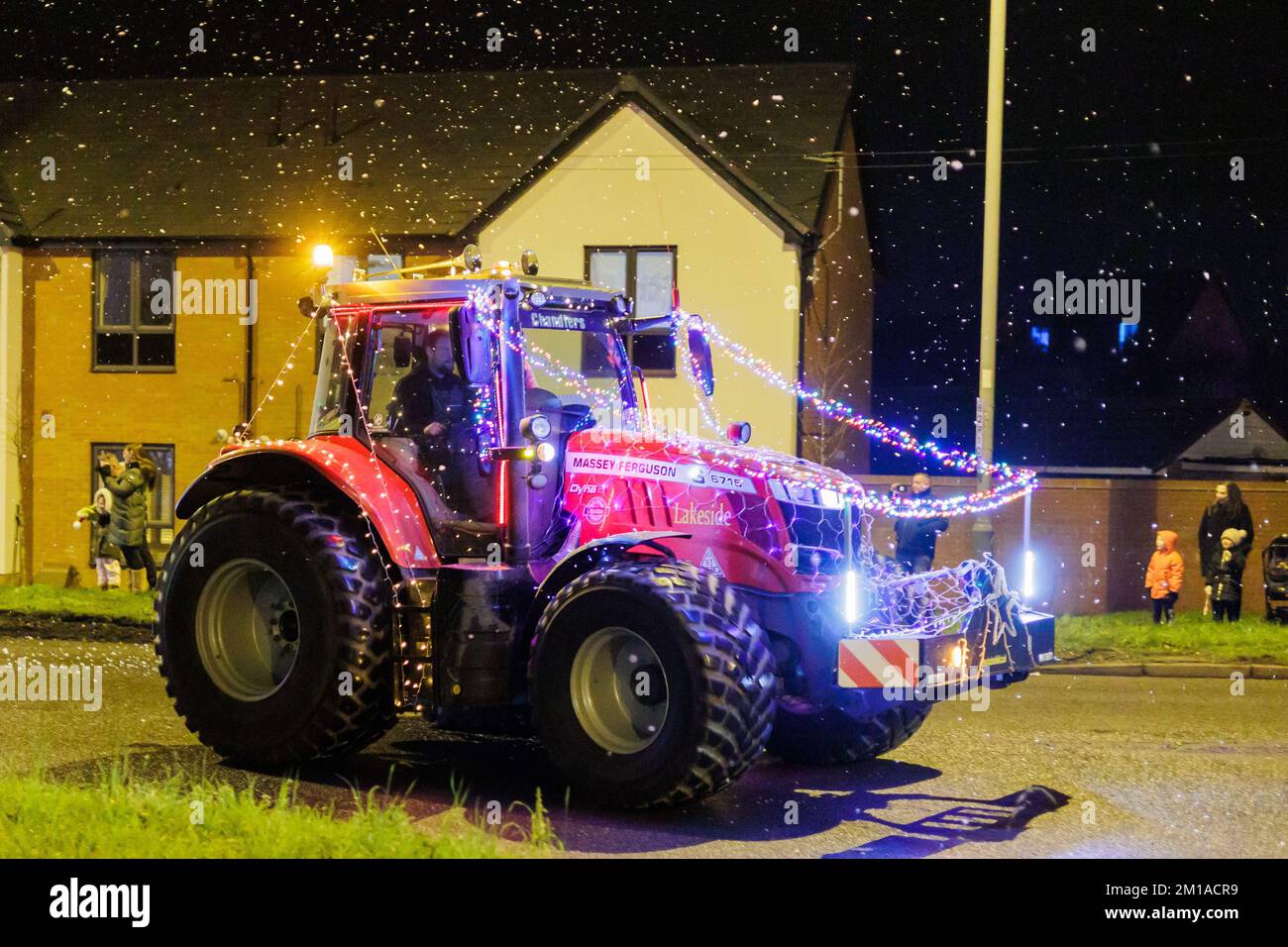 The Christmas Tractor run through North Warwickshire, England. Over fifty tractors are decorated with bright colourful lights and driven over two nights through the roads and lanes of North warwickshire. The event organised by the Sheepy Ploughing organisation raises money for charity while giving pleasure to a huge amount of people who come out to watvh the specatacle usually held a couple of weeks before Christmas. The tractors are pictured in Grendon, North Warwickshire where the A5 crosses Boot Hill. Stock Photo