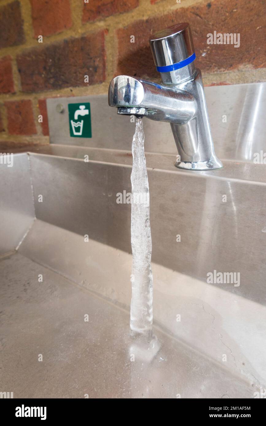 Ice column extending from a frozen tap drip so that ice is formed from the dripping water of the