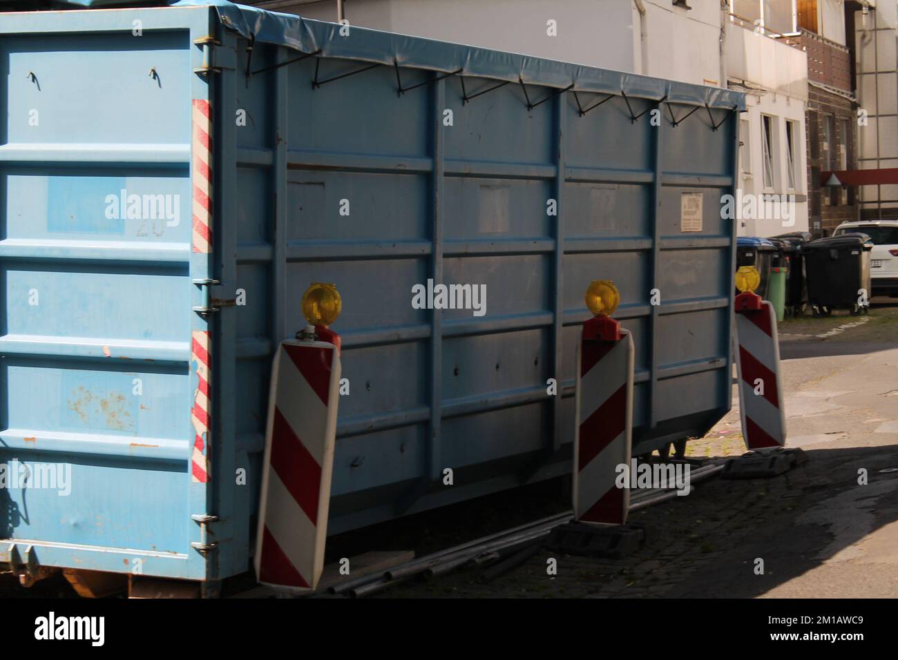A metal trash container in the middle of a city on a sunny day Stock ...