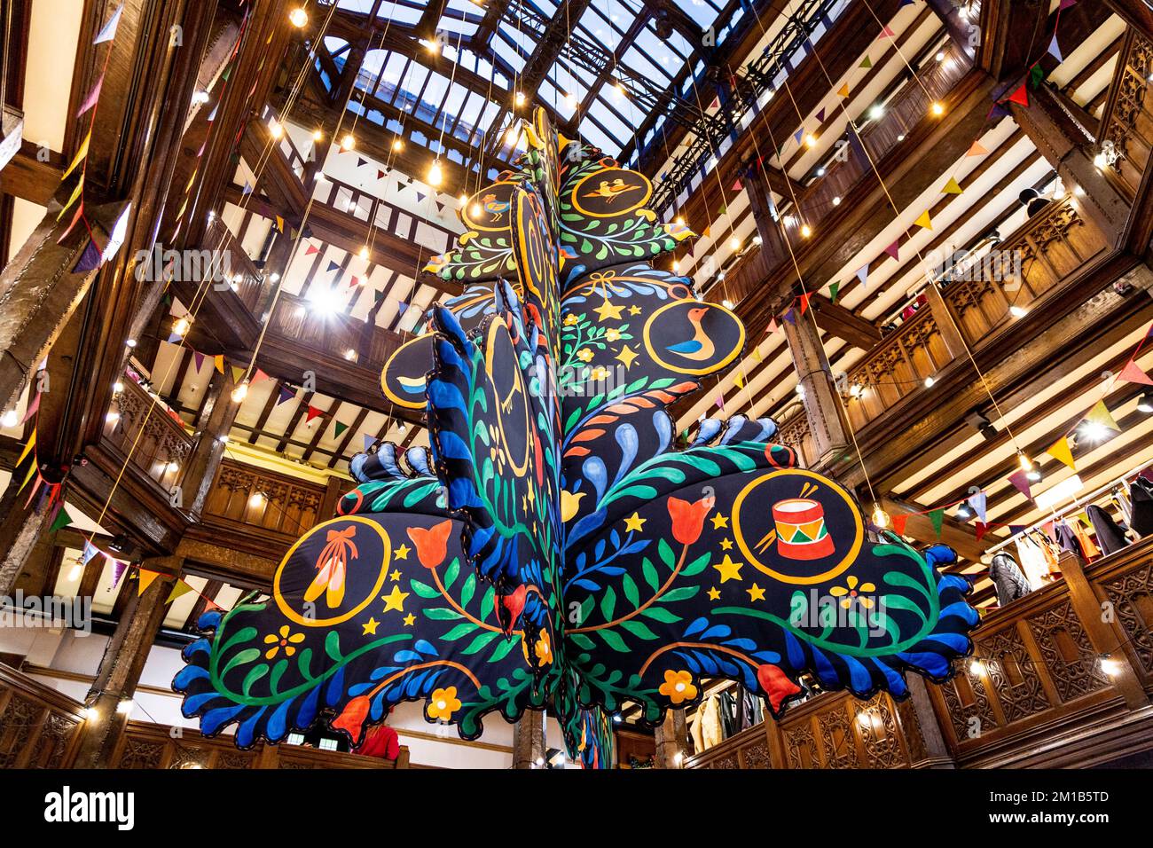 A large Christmas tree suspended from the ceiling at Liberty London, UK Stock Photo