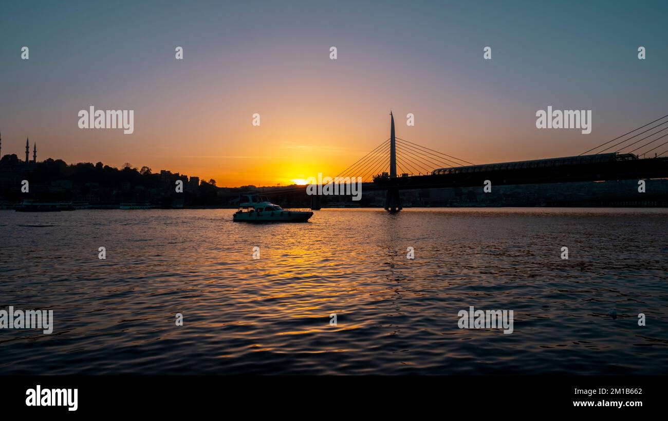 Beautiful sunset, Golden hours, Golden Horn metro bridge and the view of the Golden Horn in Istanbul, the sunset, the birds heading towards the sun, Stock Photo