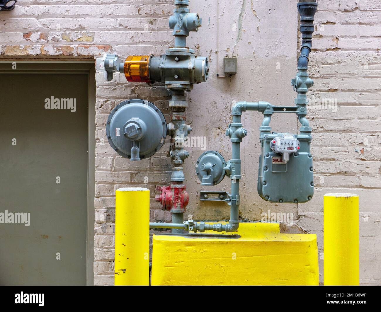 Natural gas supply line and meter on masonry building. Methane in