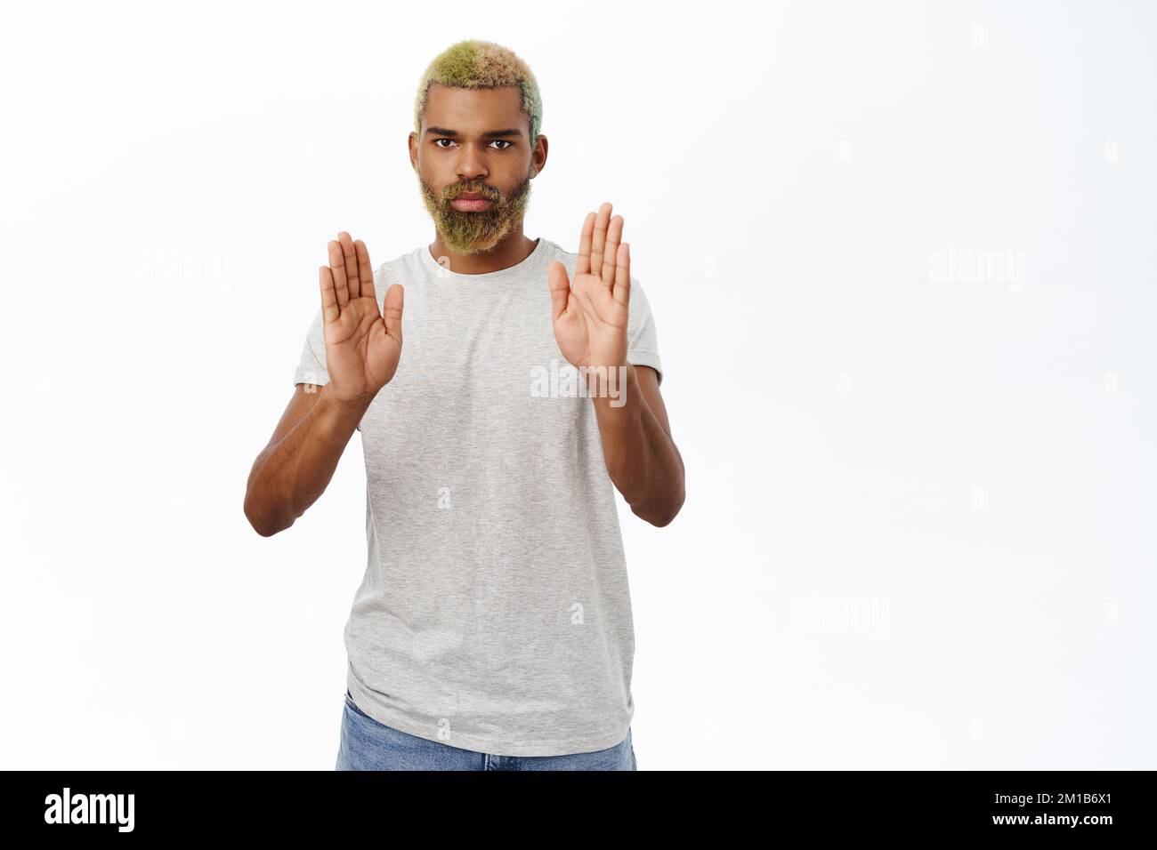Man looks concerned, shows stop, prohibit gesture, pause, standing over ...