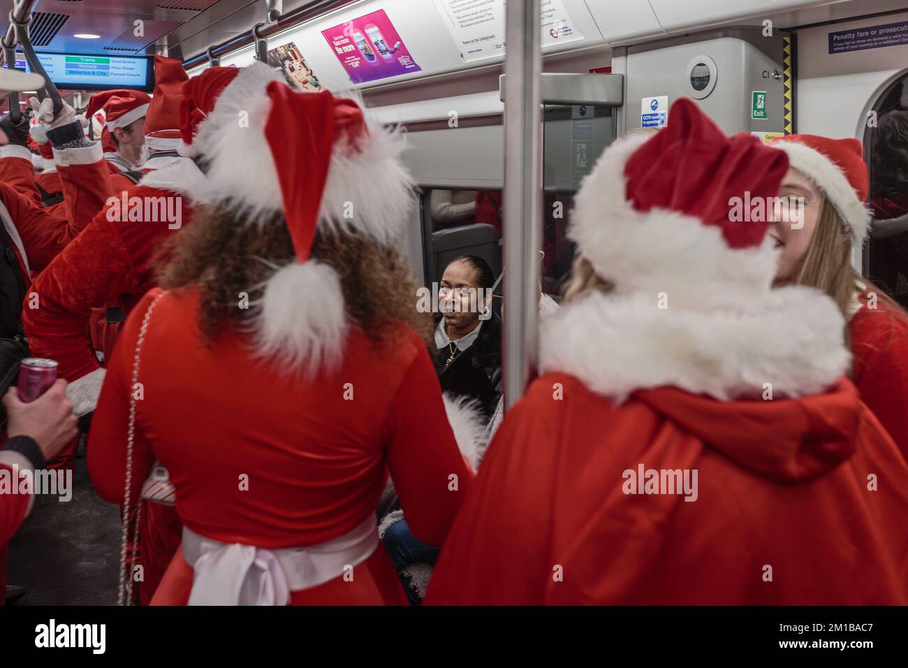 A member of the public reacts to the invasion of santas on the tube in London. Stock Photo