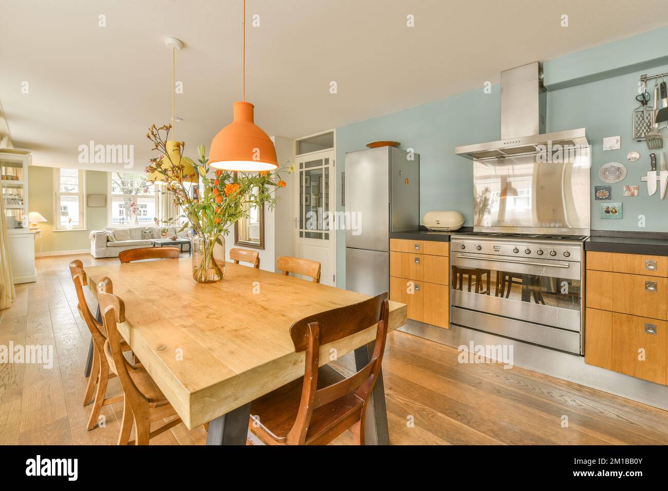 a kitchen and dining area in a house with wood floors, light blue walls