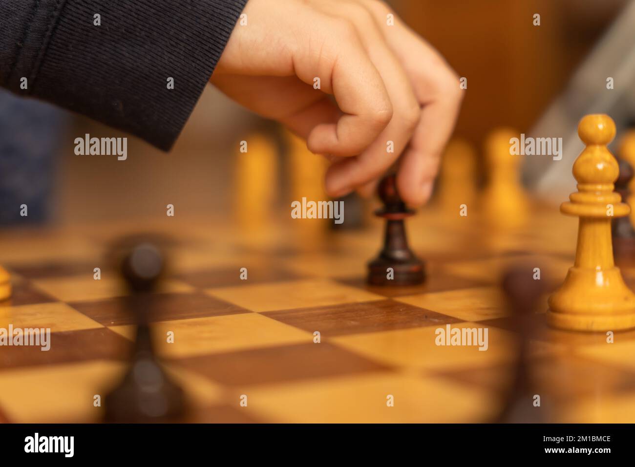 Soft focus of anonymous person moving pawn on board during chess game in daytime Stock Photo