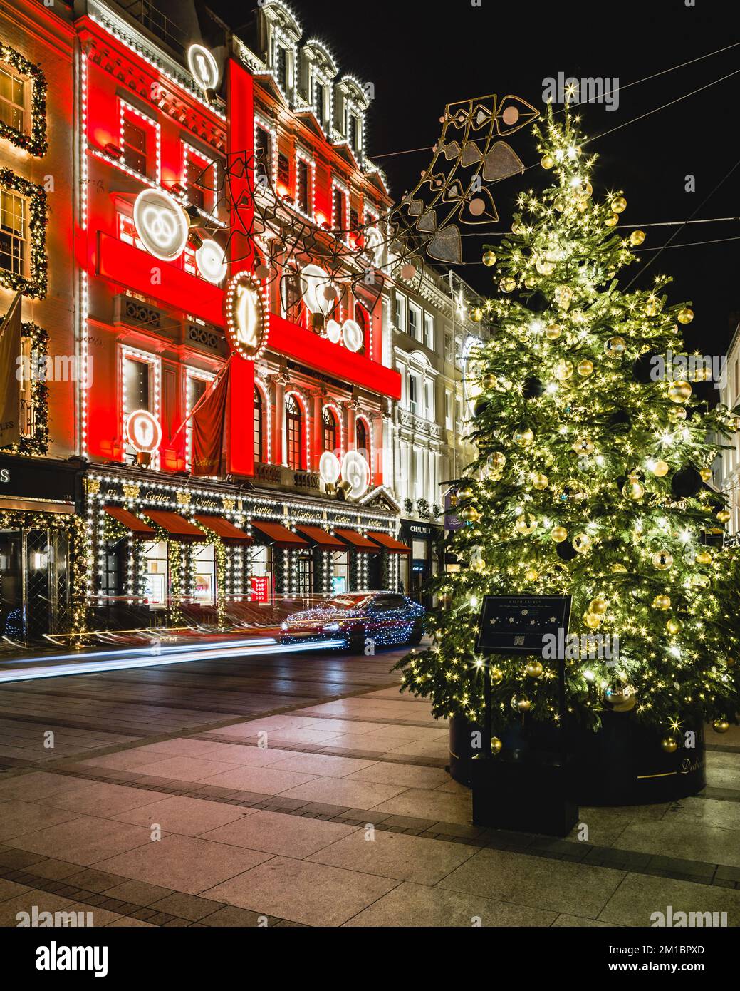 Light trails from a luxury and illuminated car outside the iconic Cartier store in London during the christmas season. Stock Photo