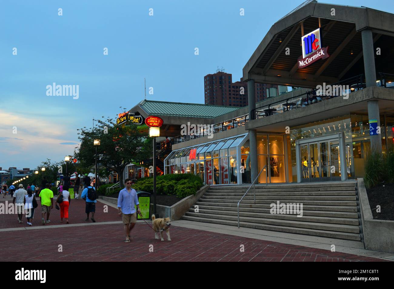 People walk amongst the shops, restaurants and cafes of the Inner Harbor district, an entertainment and business area in Baltimore Stock Photo