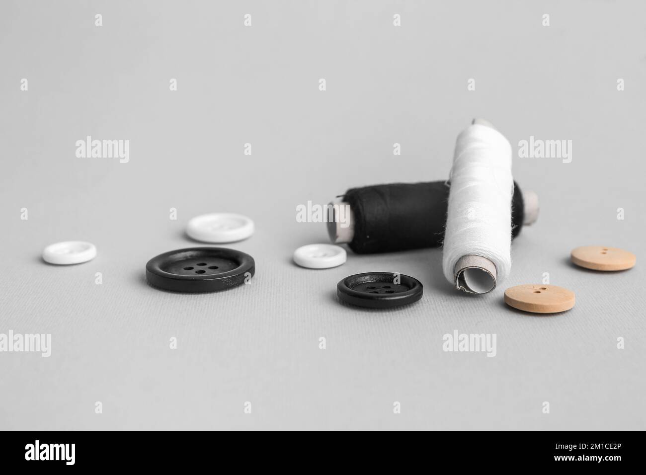 Thread spools with buttons on grey background Stock Photo
