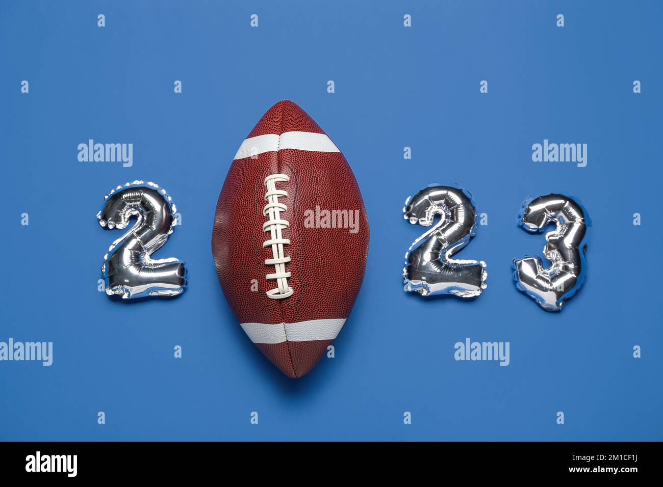 Figure 2023 made of balloons with rugby ball on blue background Stock