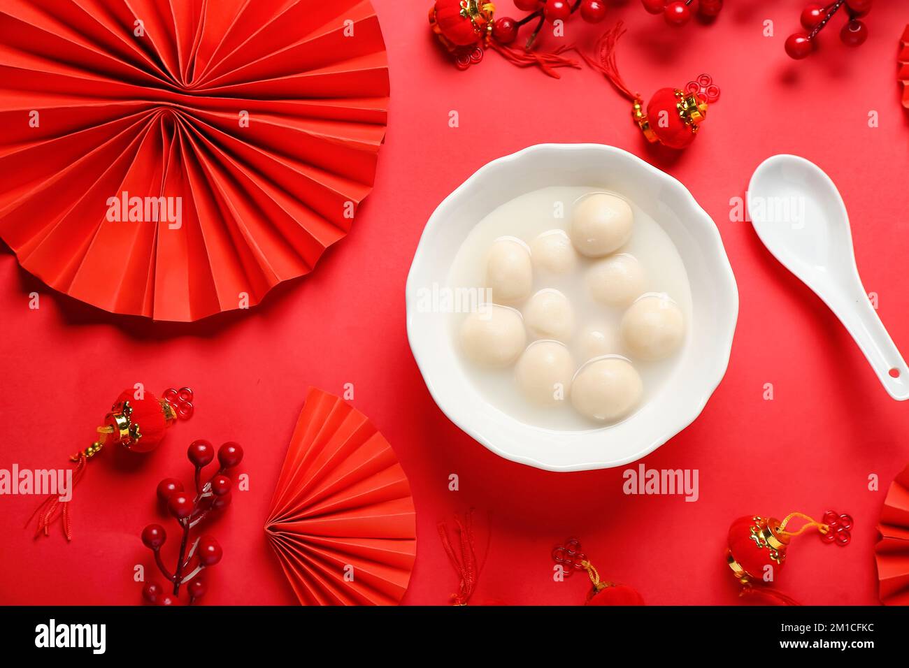Bowl of tasty tangyuan and Chinese decor on red background. Dongzhi ...