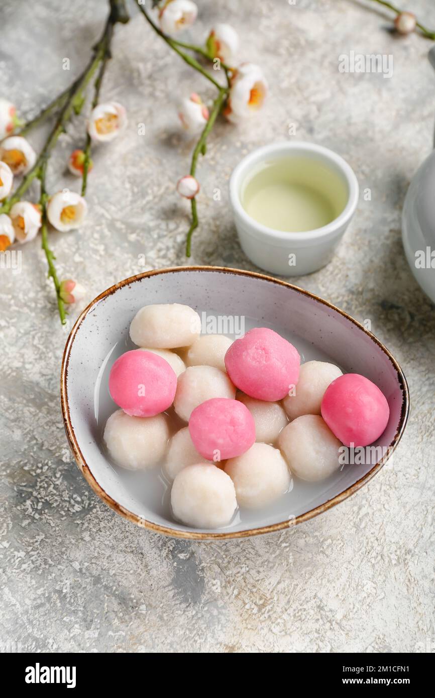 Bowl of tangyuan, cup and sakura on grunge background. Dongzhi Festival ...