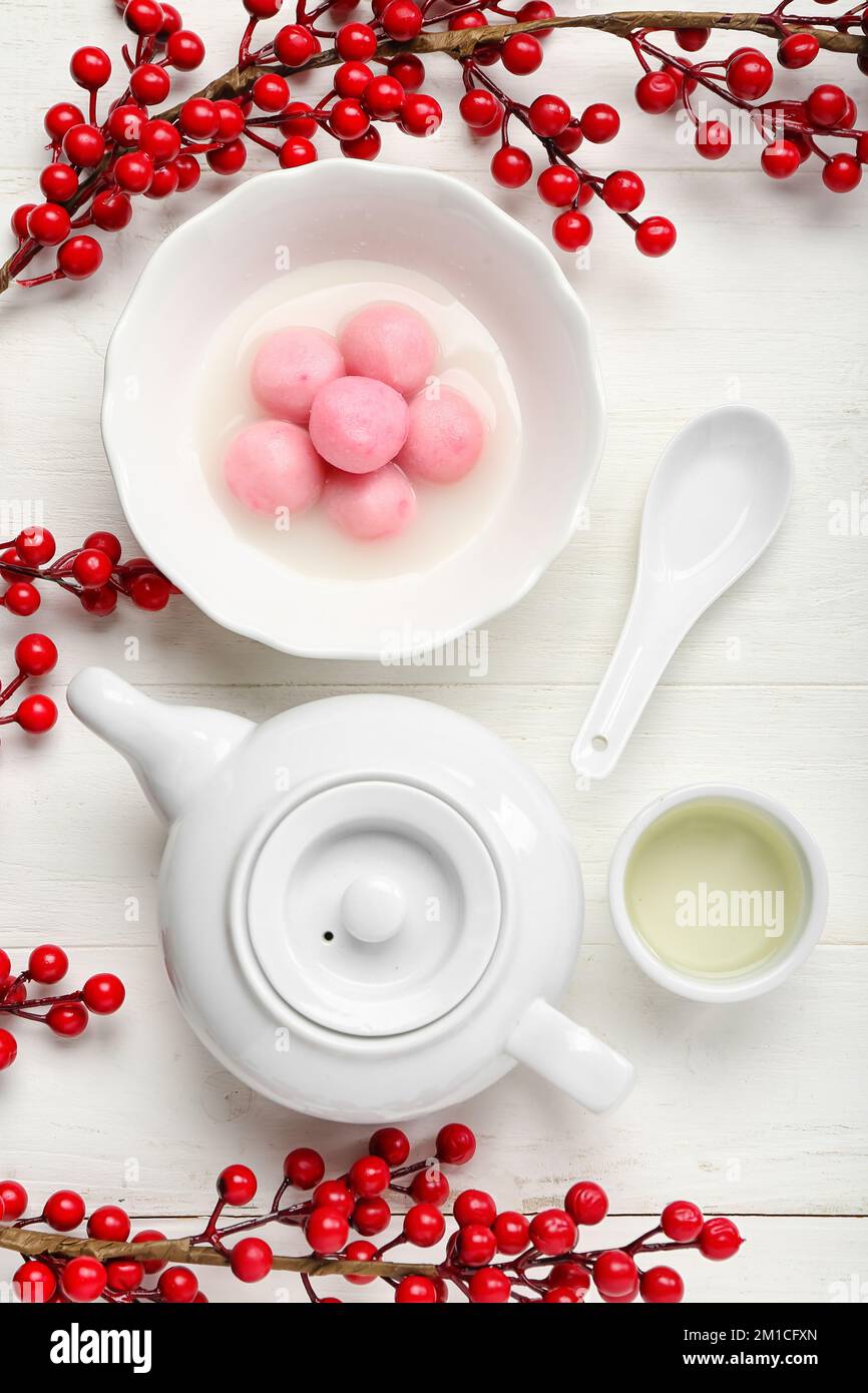 Bowl of tangyuan with teapot, cup and berries on white wooden ...