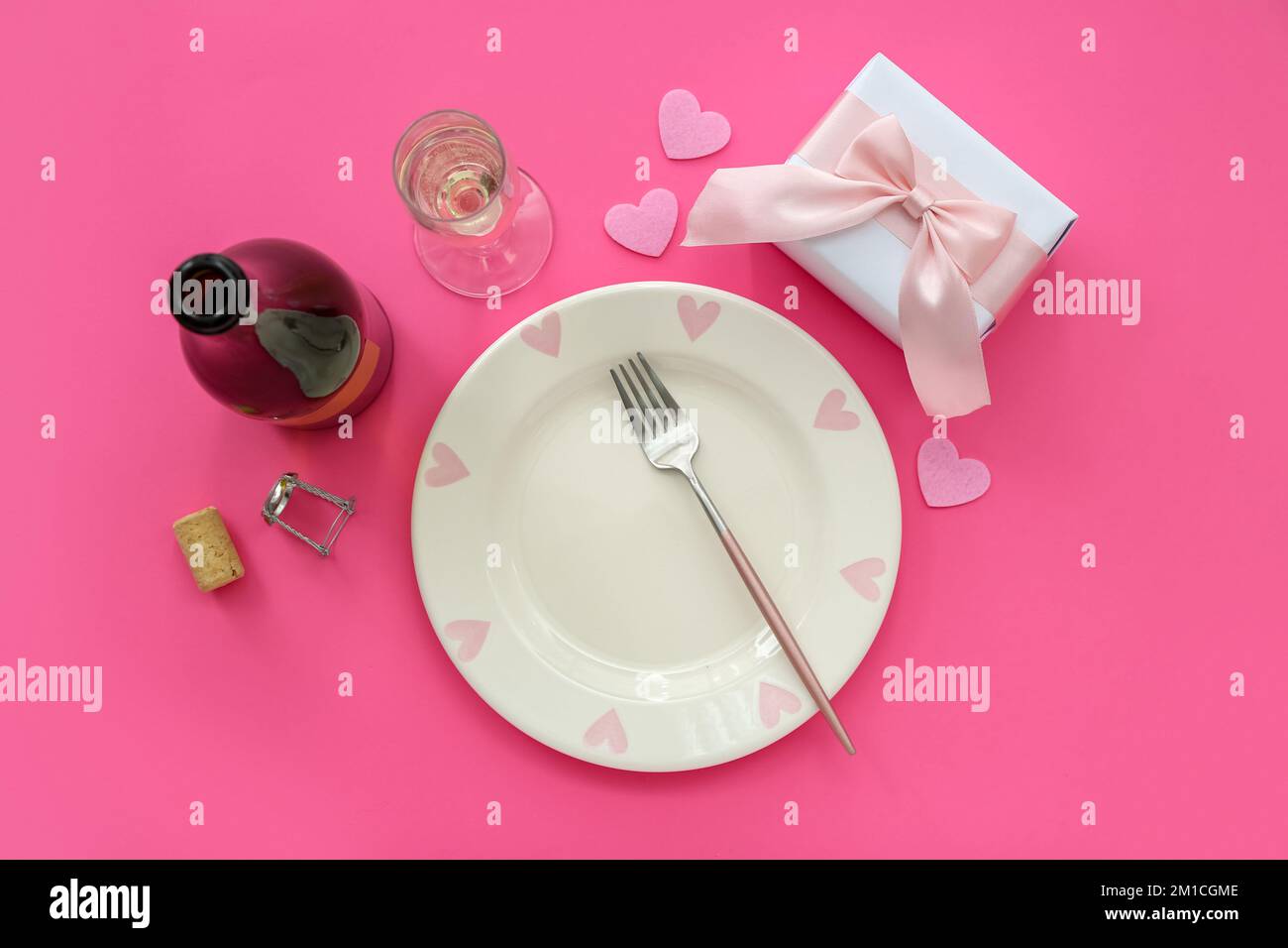 Table setting for Valentine's Day with gift and hearts on pink ...