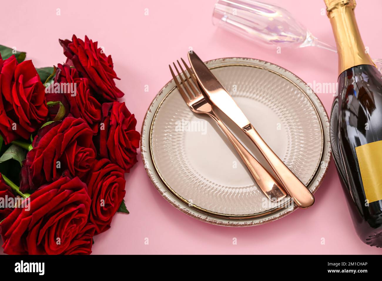 Table setting for Valentine's Day with red roses on pink background ...