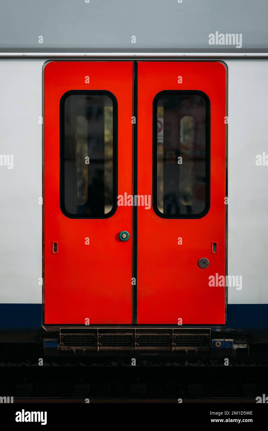 Modern technologies for opening sliding doors of an electric train car using a touch button. Closed red doors of a passenger car as part of a subway Stock Photo