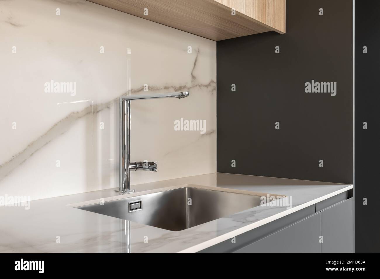 Closeup side view of contemporary design square metal sink embedded in