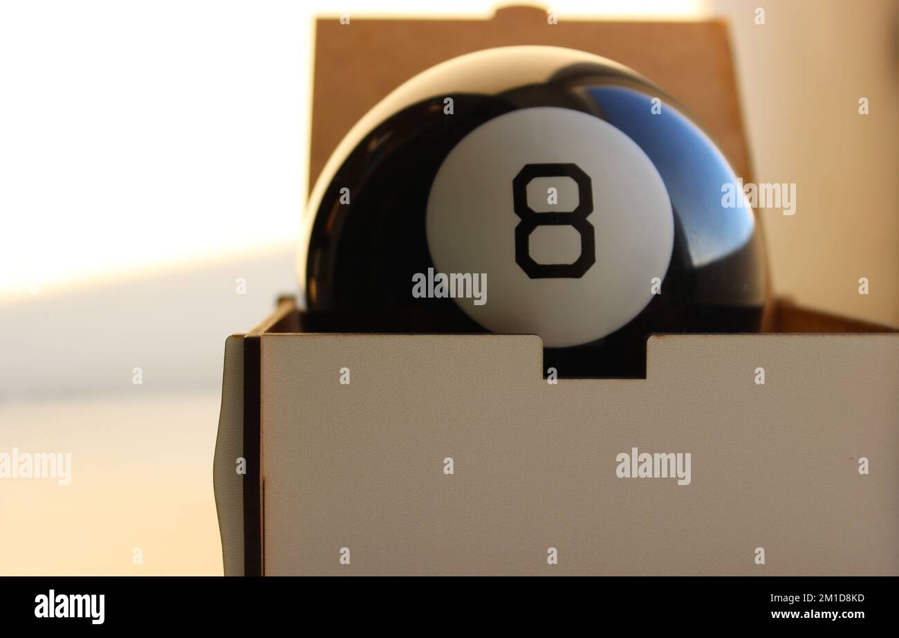 Black pool ball number eight inside a wooden case closeup stock photo Stock Photo