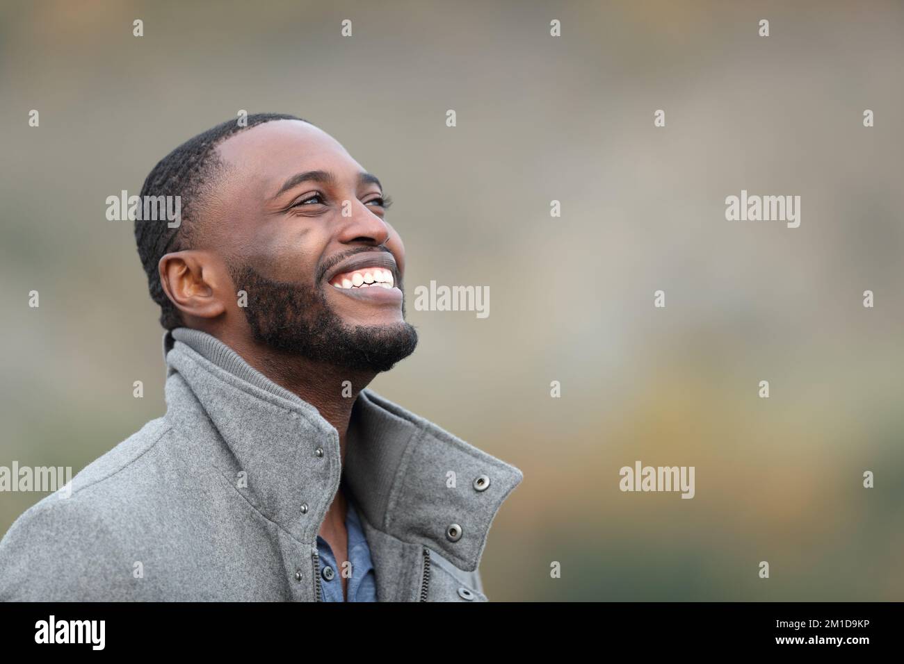 Happy black man laughing looking up in winter outdoors Stock Photo