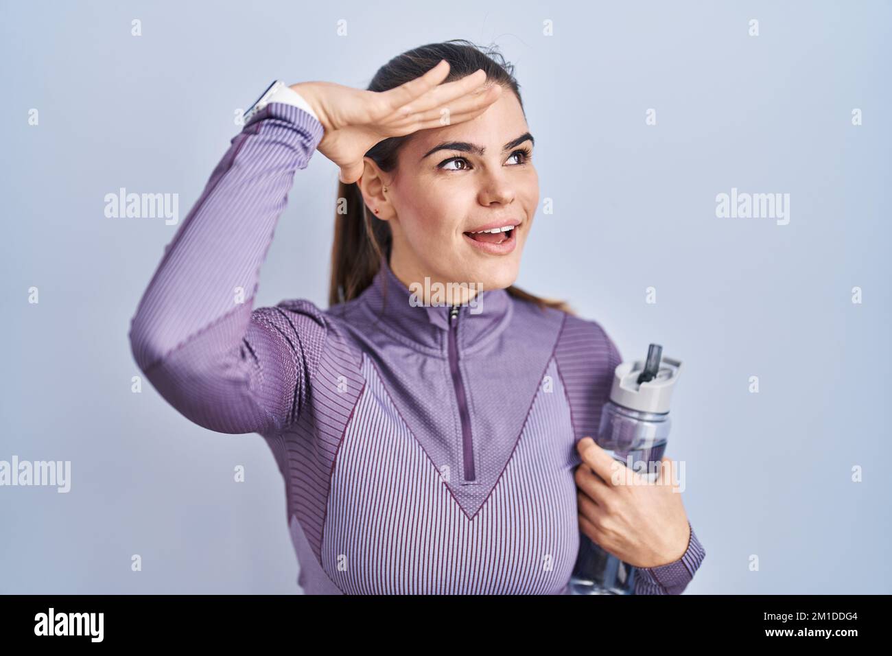 Beautiful woman wearing sportswear holding water bottle very happy and ...