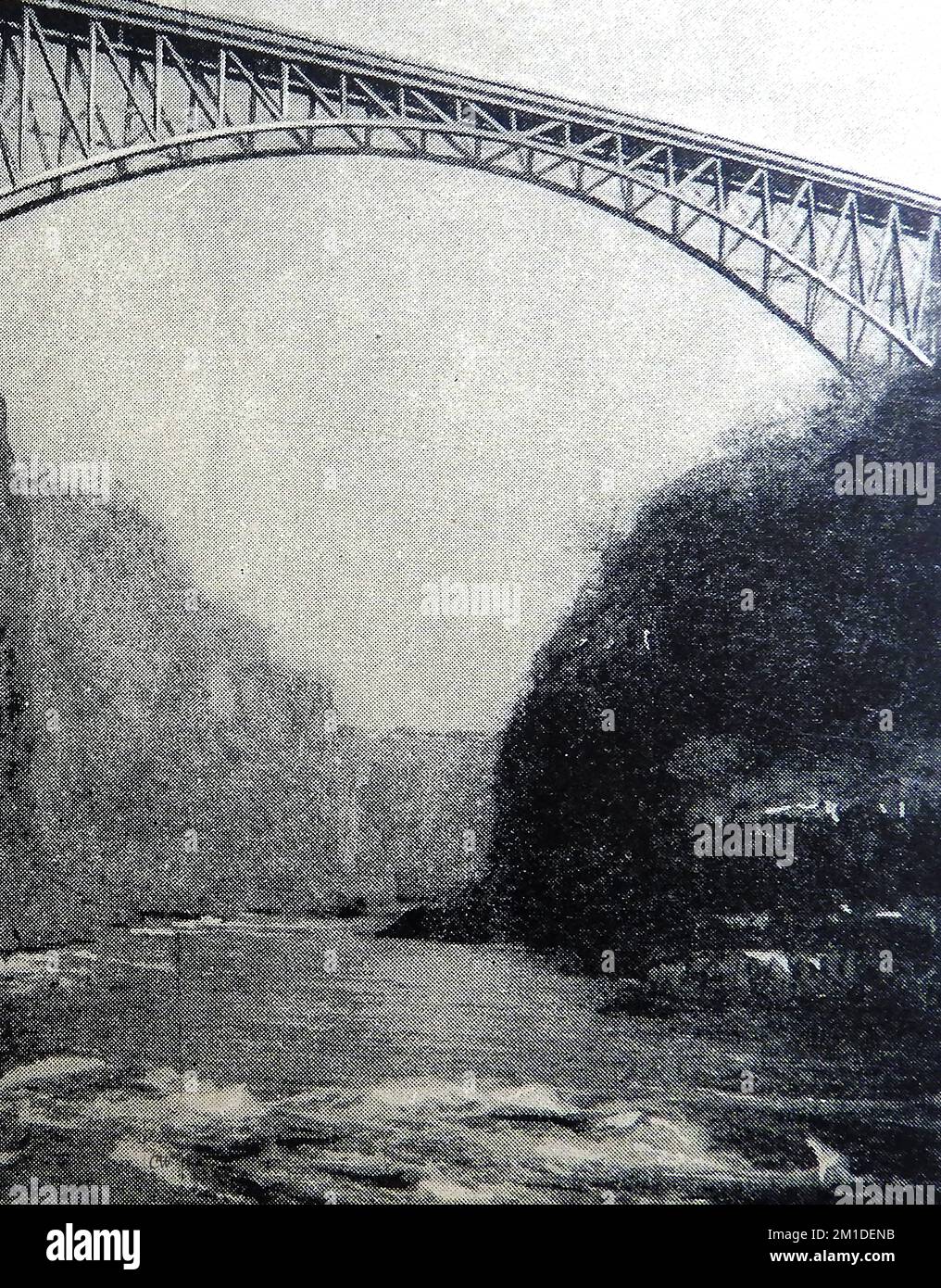 Circa 1930 view of the river Zambesi (Zambezi)  near Victoria Falls, South Africa showing the single span railway bridge. Stock Photo