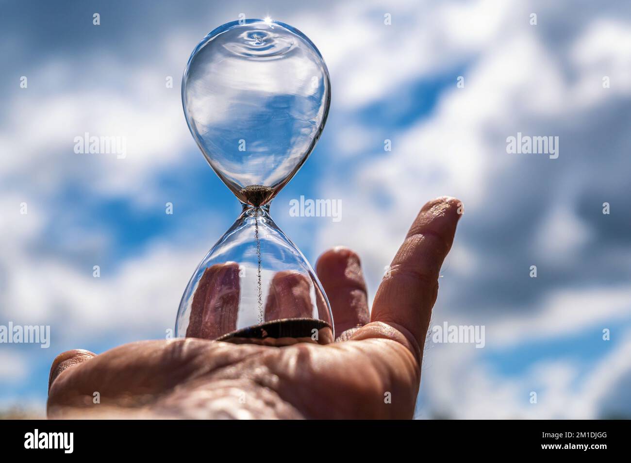 The expiry of time to protect the climate represented by an hourglass in front of the sky Stock Photo