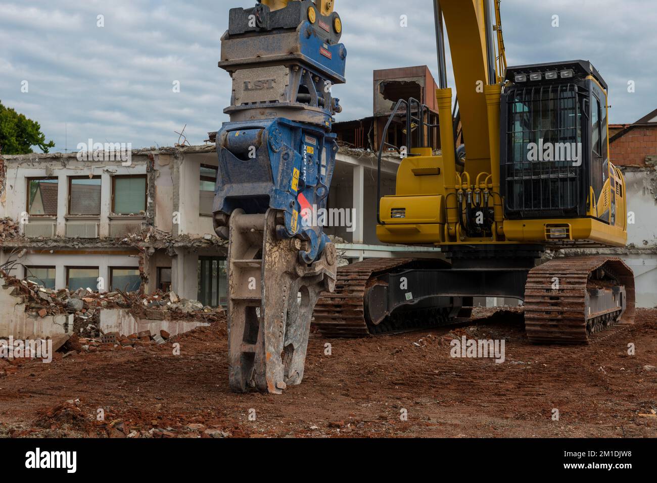 Digger taking down a big house Stock Photo