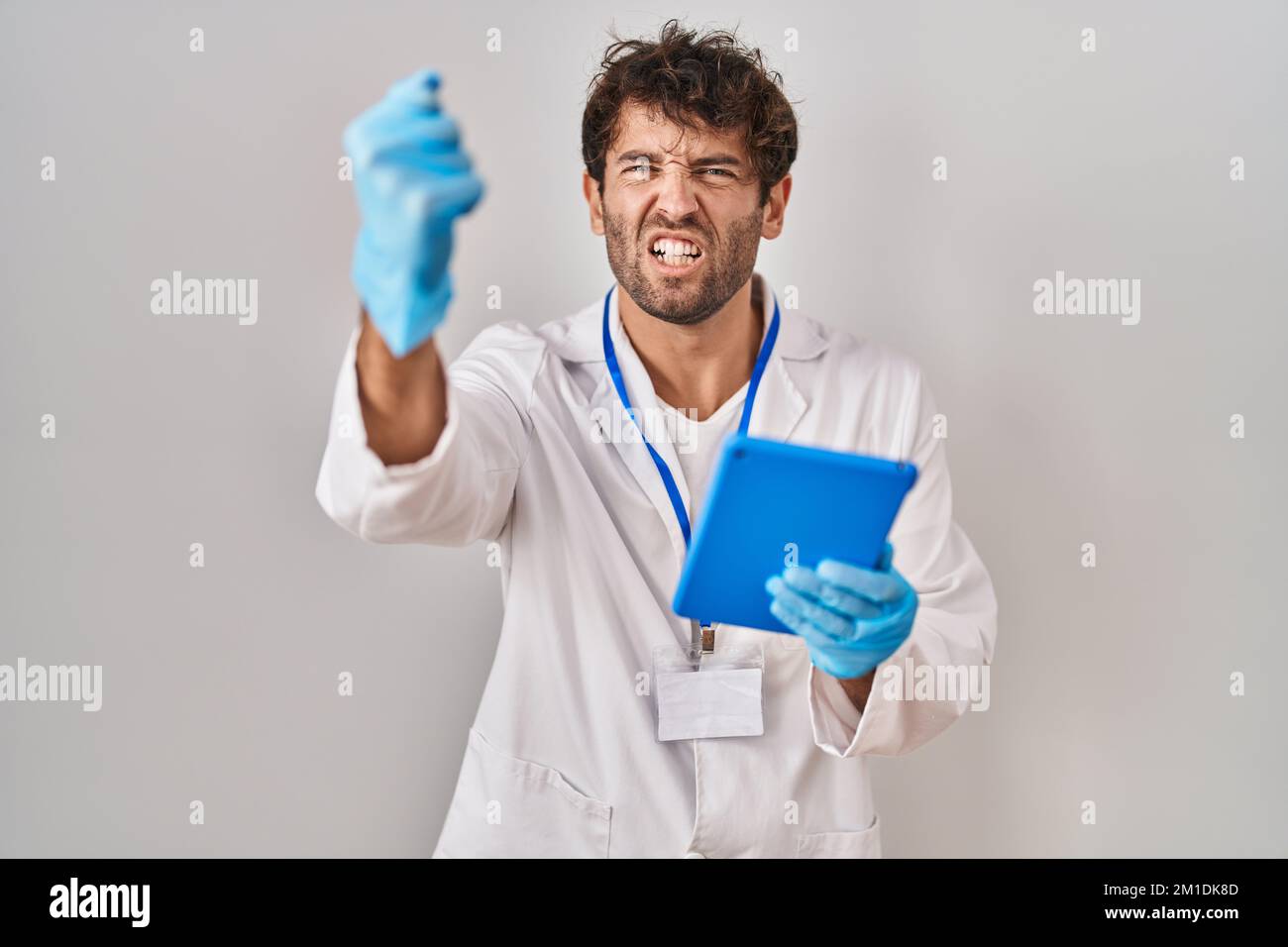 Hispanic scientist man working with tablet annoyed and frustrated ...