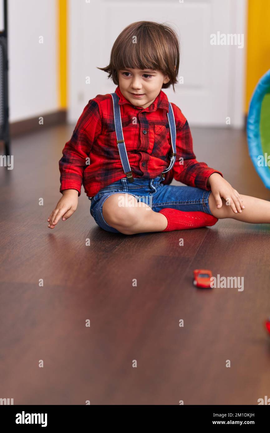Adorable toddler playing with cars toy sitting on floor at home Stock ...